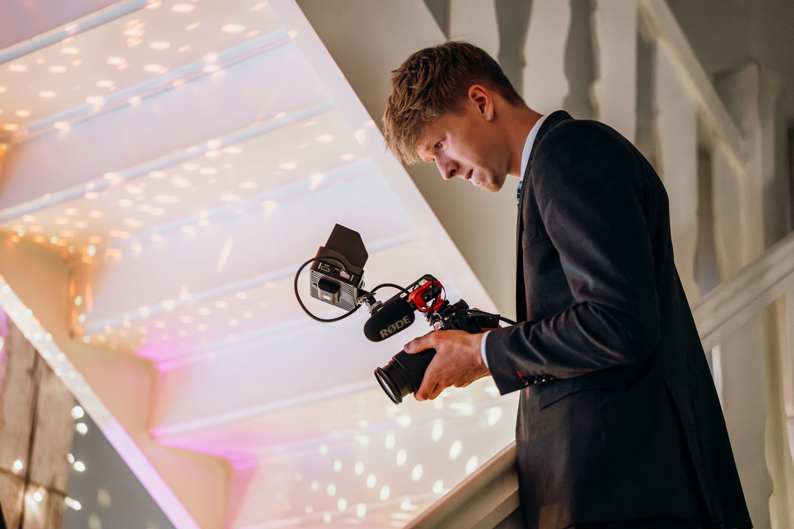 Oscar Kamps filmt mit Kamera und RØDE-Mikrofon von einer Galerie herab